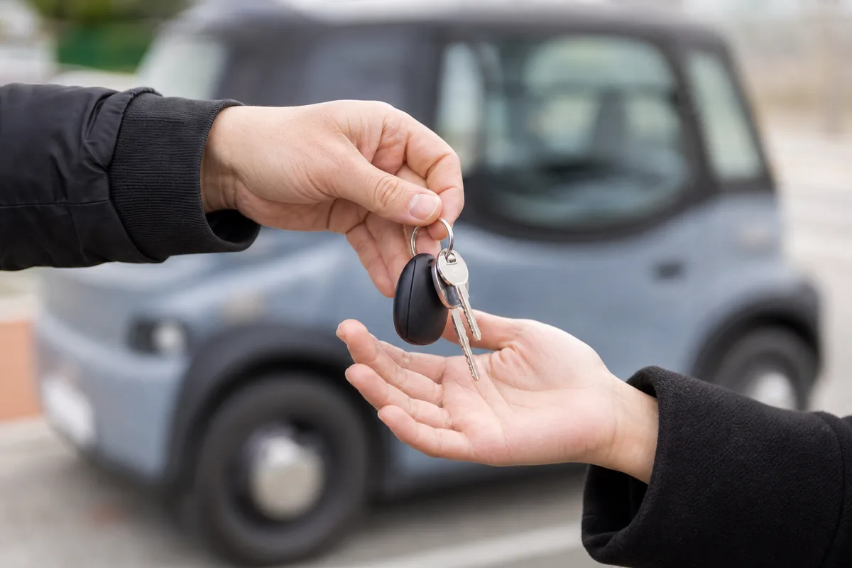 Jeune conducteur récupérant les clés d&rsquo;une voiturette auprès d&rsquo;un loueur